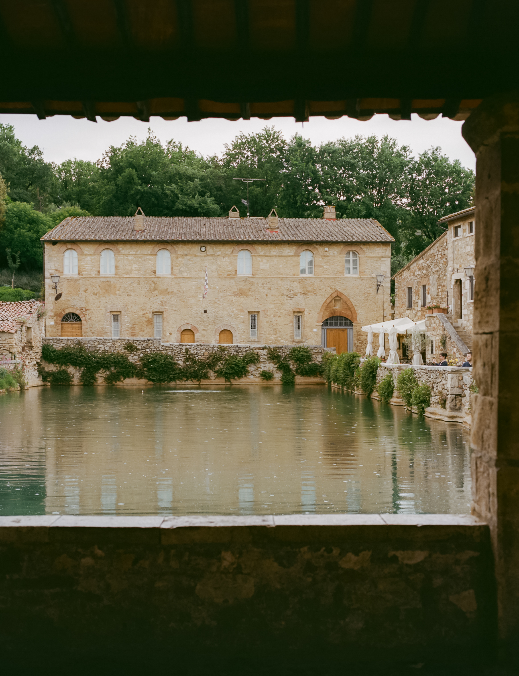 a pool of water with a stone building in the background