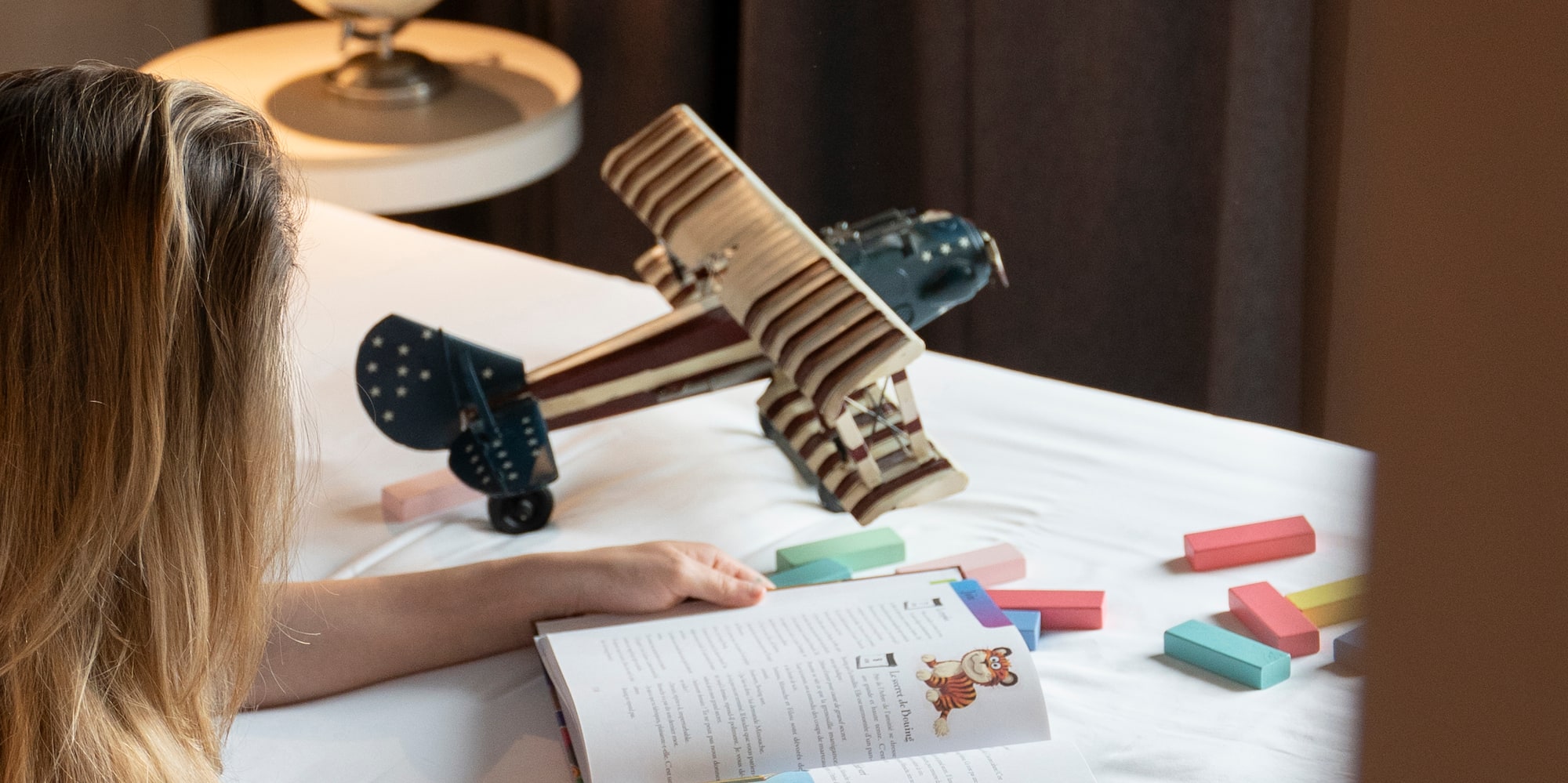 a woman lying on a bed reading a book