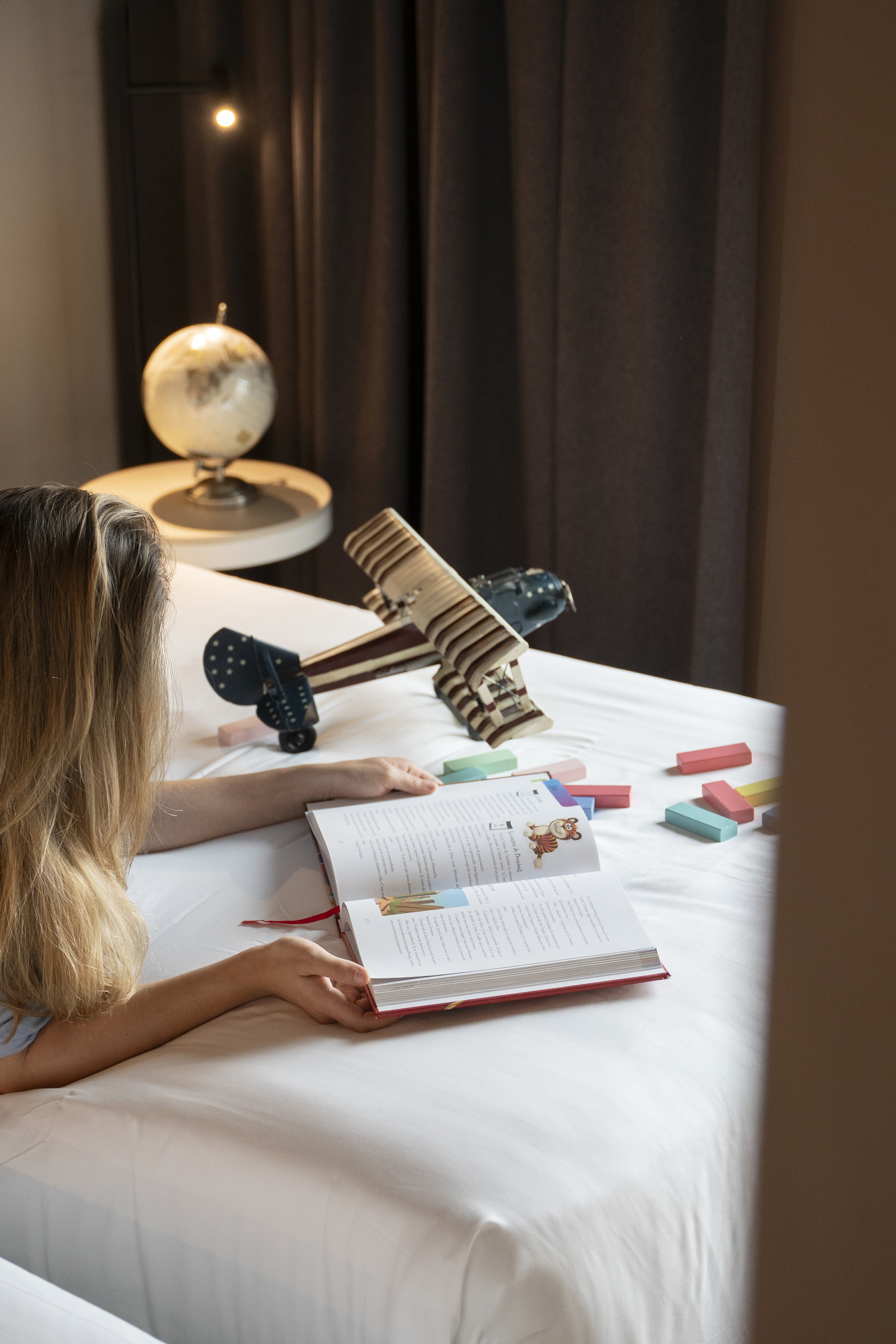 a woman lying on a bed reading a book
