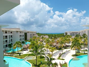 a pool with palm trees and buildings in the background