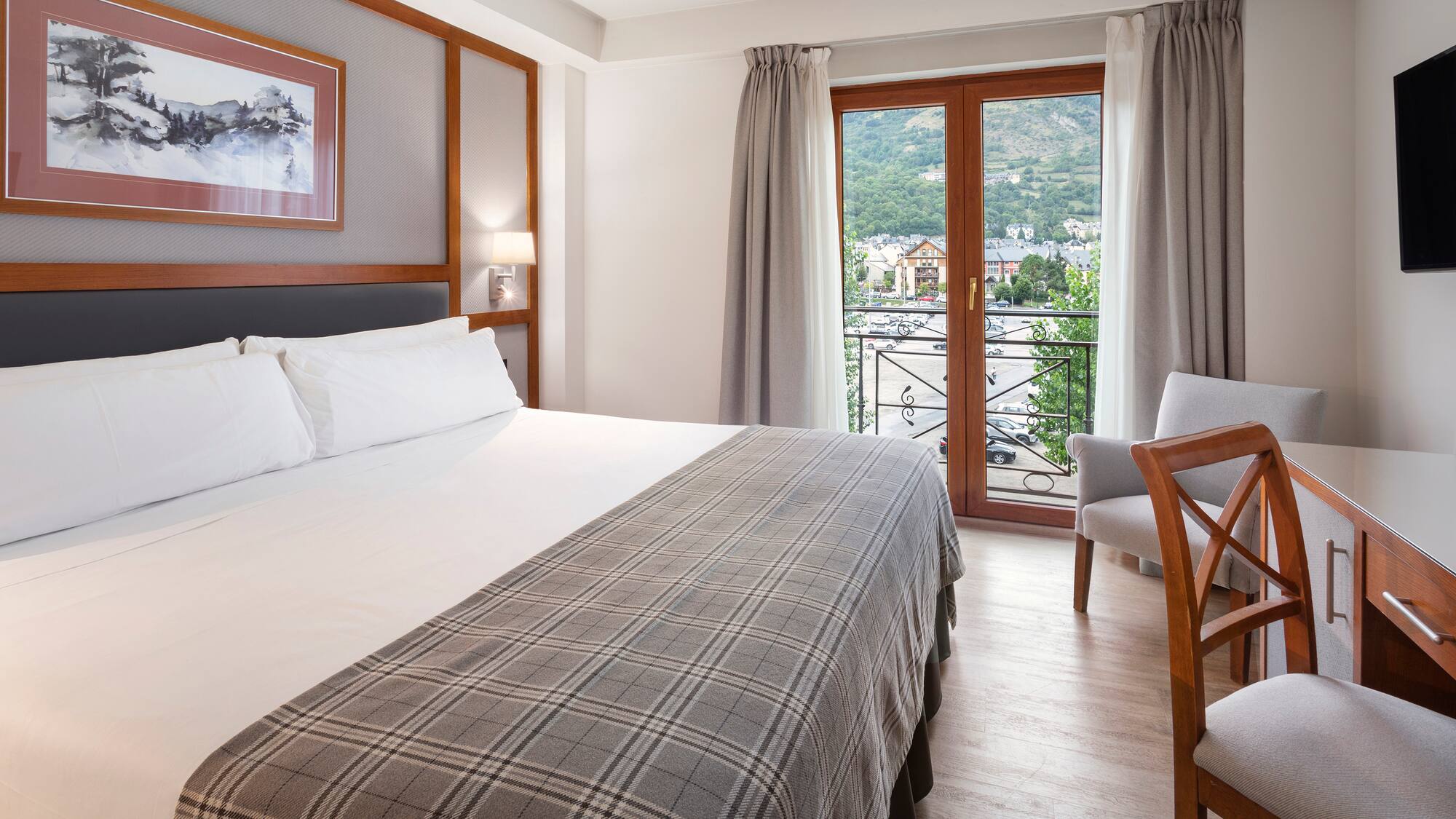 a bed with a chair and a table in a room with a balcony