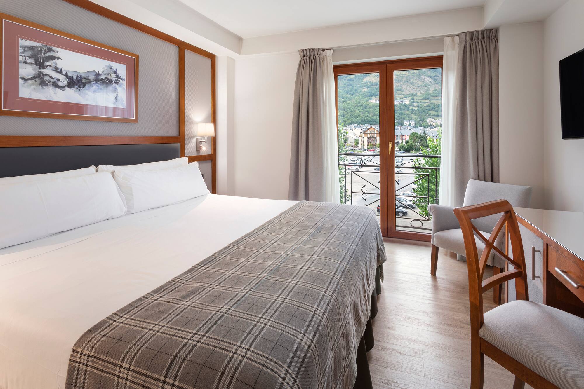 a bed with a chair and a table in a room with a balcony