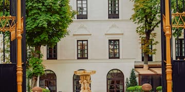 a gated courtyard with a fountain and tables and chairs