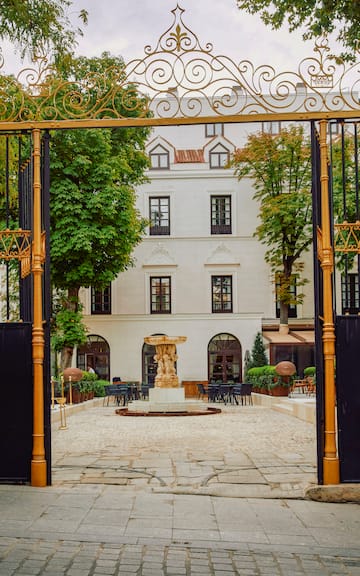 a gated courtyard with a fountain and tables and chairs
