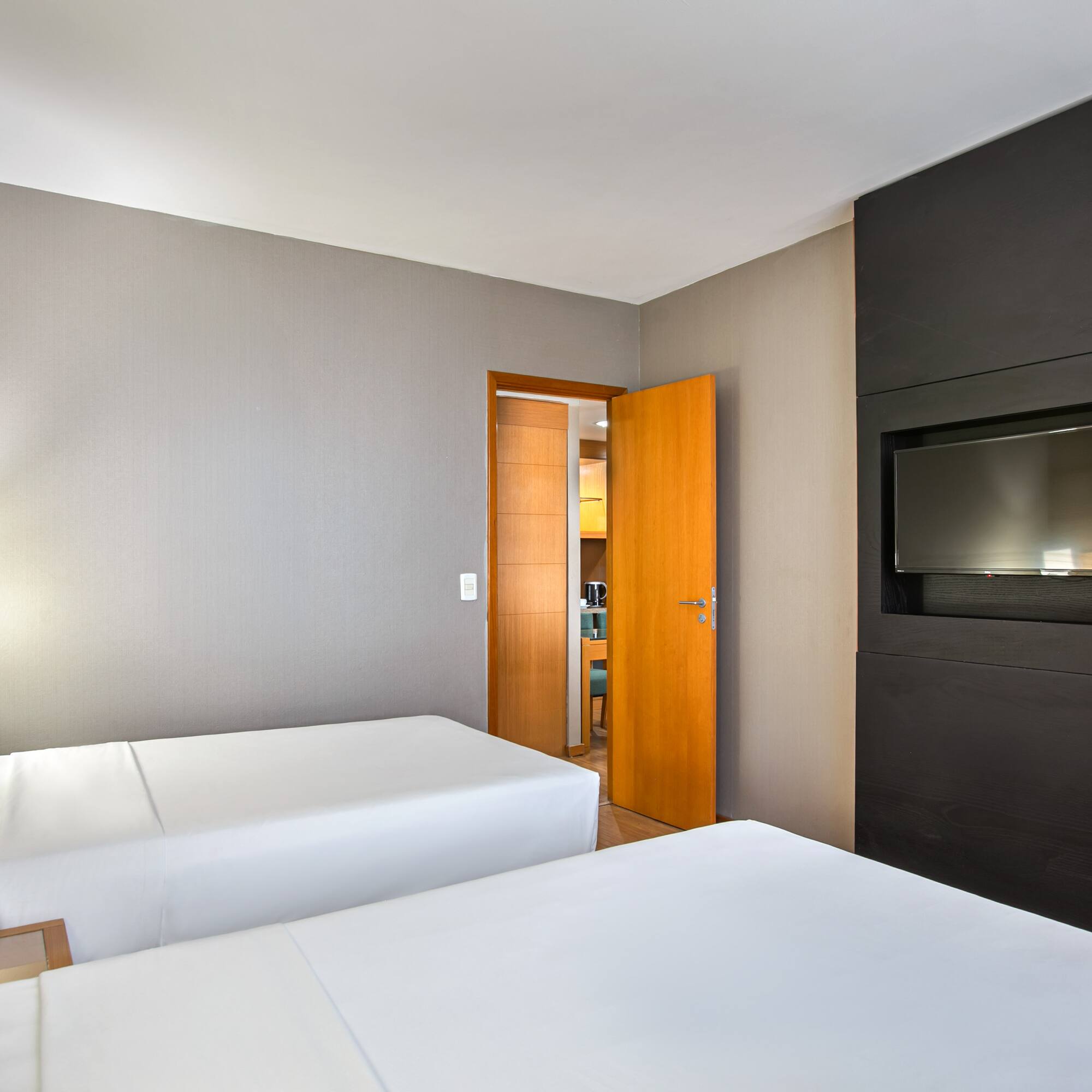 Hotel twin bedroom with contemporary decor and flat-screen TV.
