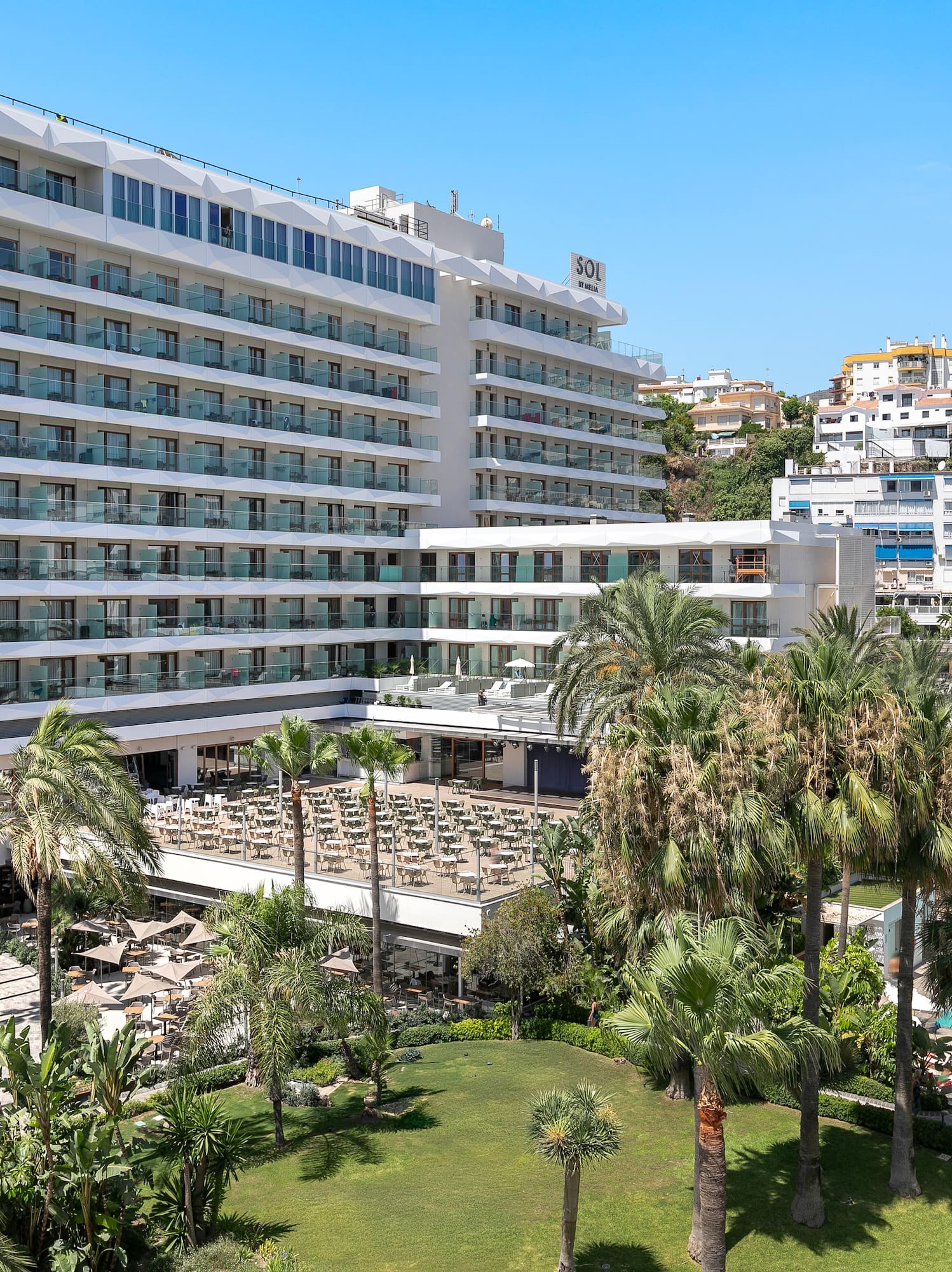 a large white building with many windows and a pool