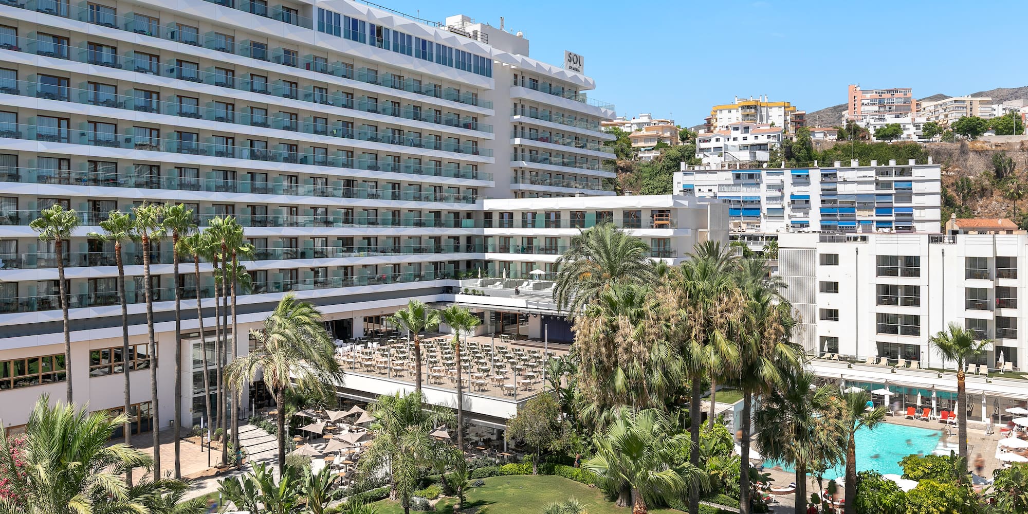 a large white building with many windows and a pool