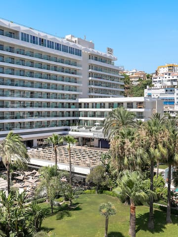 a large white building with many windows and a pool