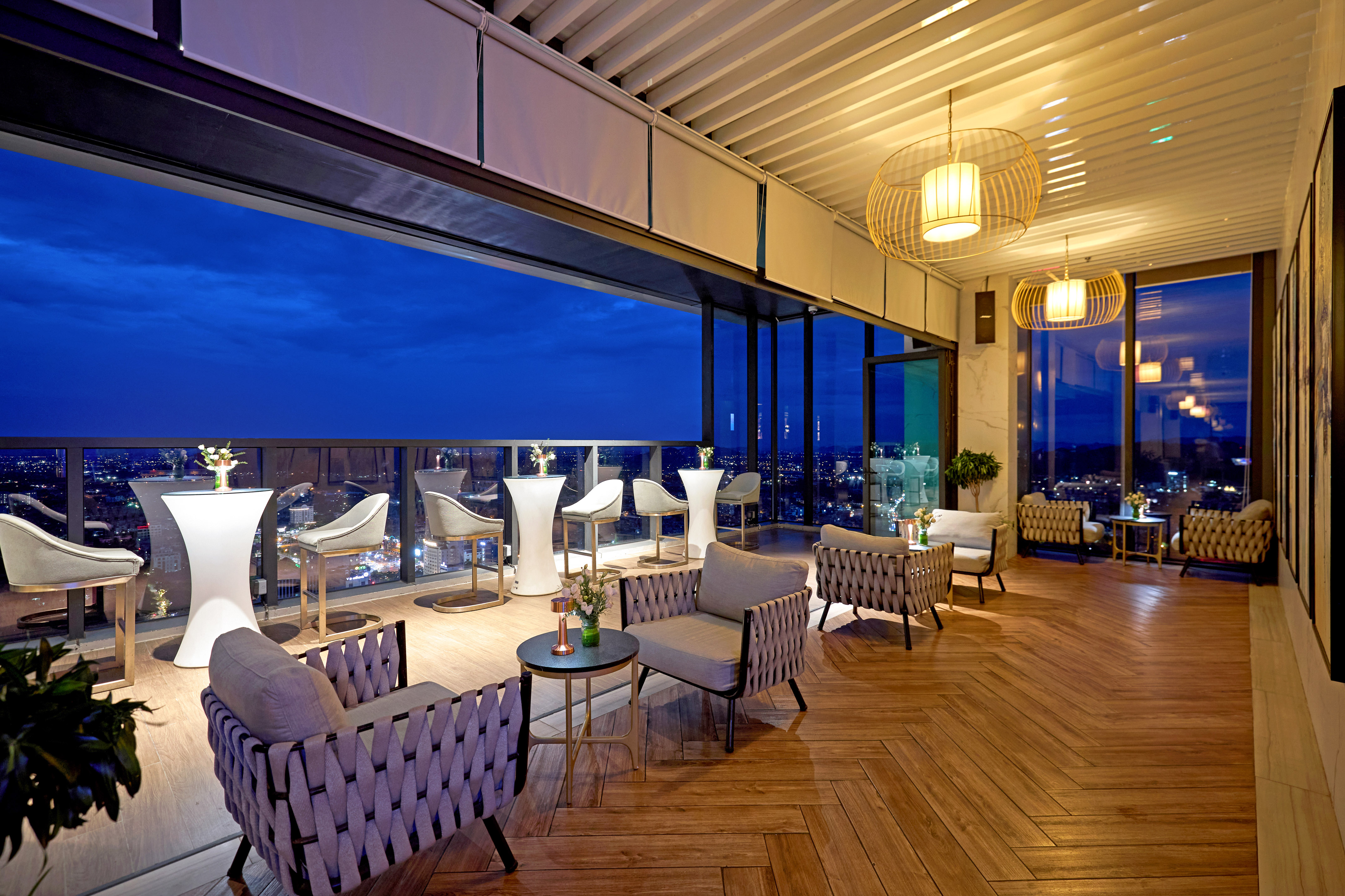 a room with chairs and tables and a view of the city