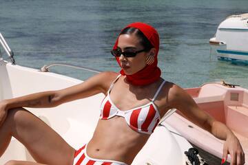 a woman in a garment and sunglasses sitting on a boat