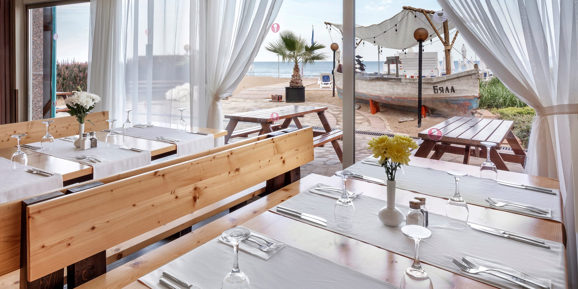 a restaurant with tables and chairs and a view of the beach