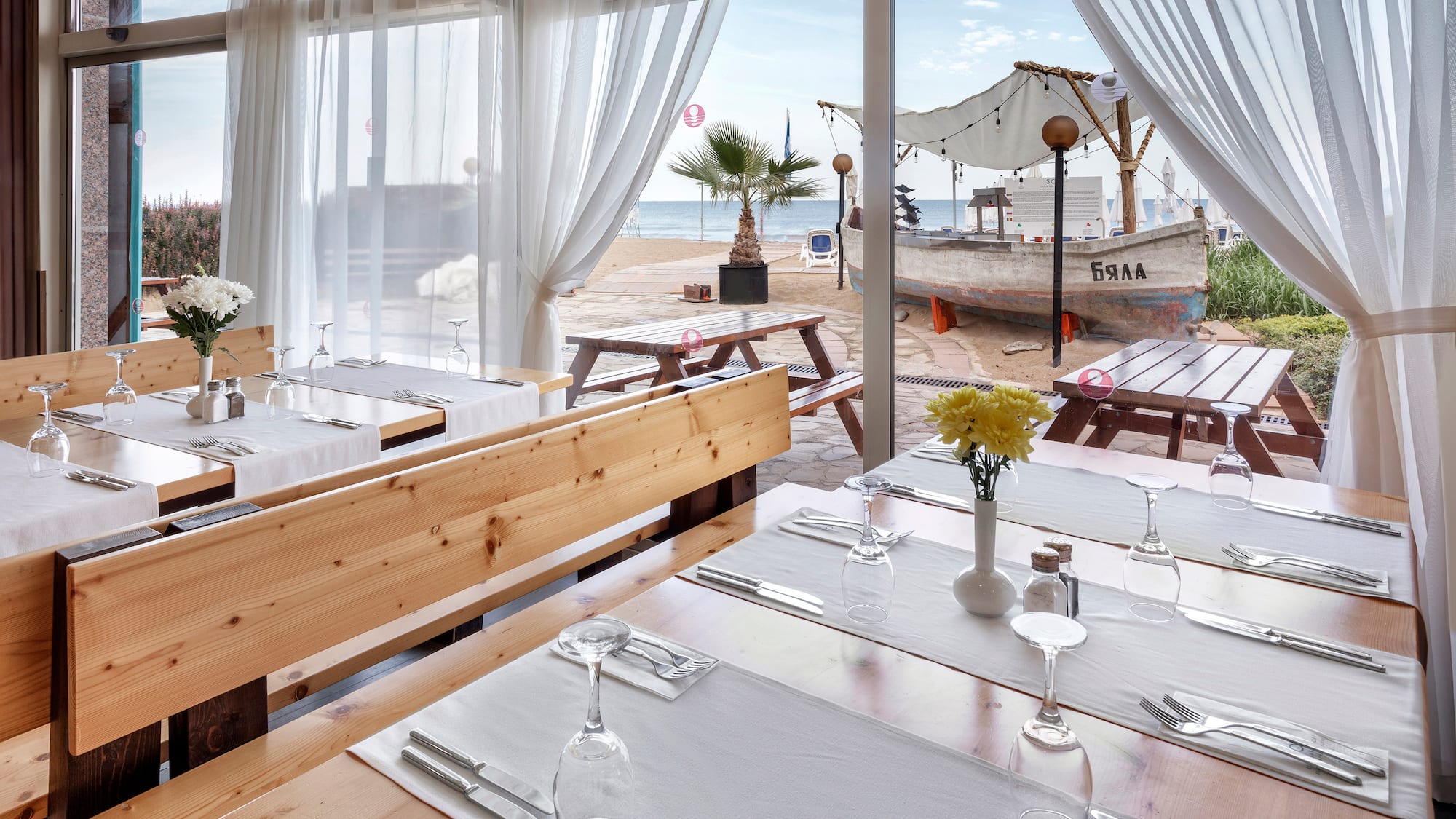a restaurant with tables and chairs and a view of the beach