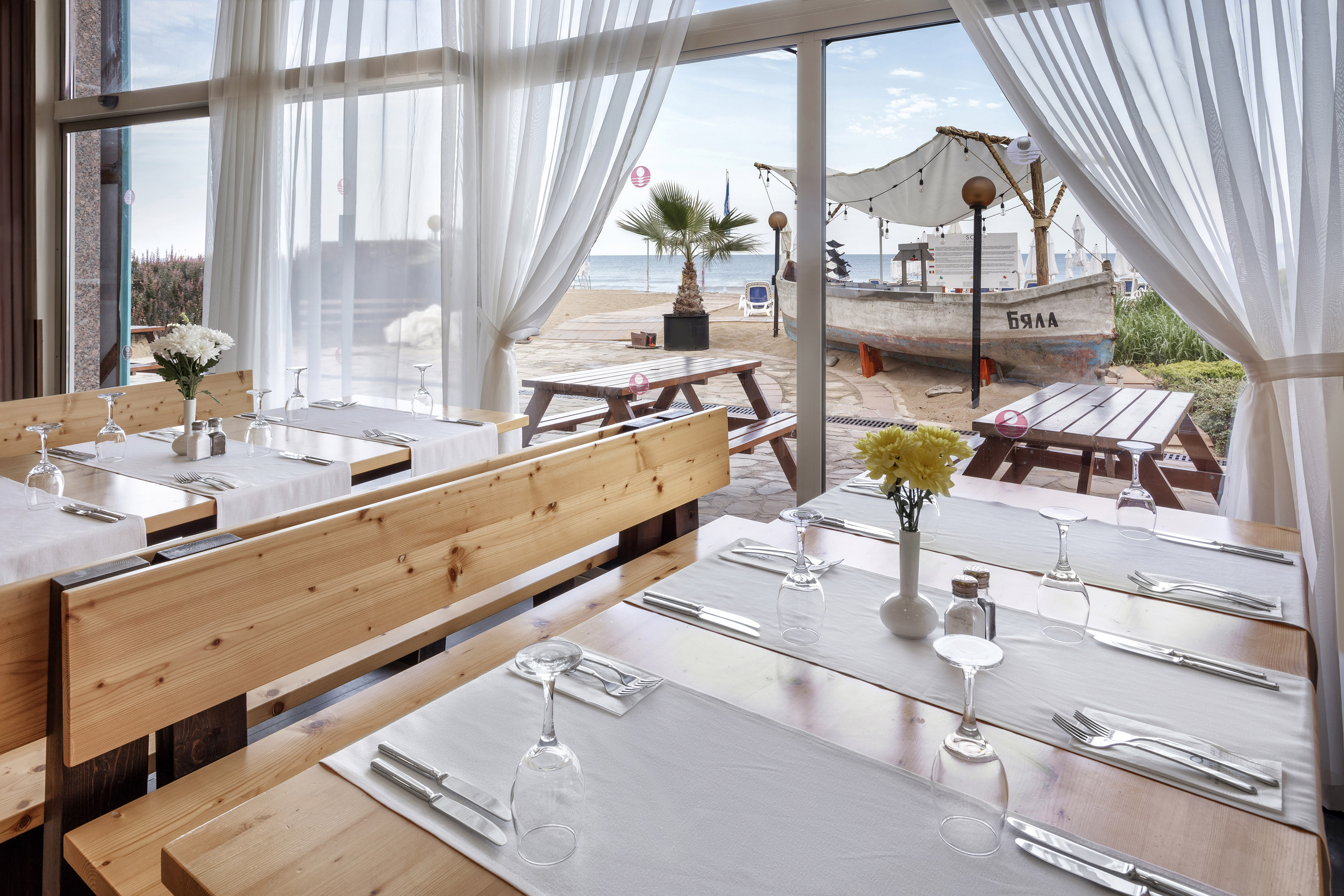a restaurant with tables and chairs and a view of the beach