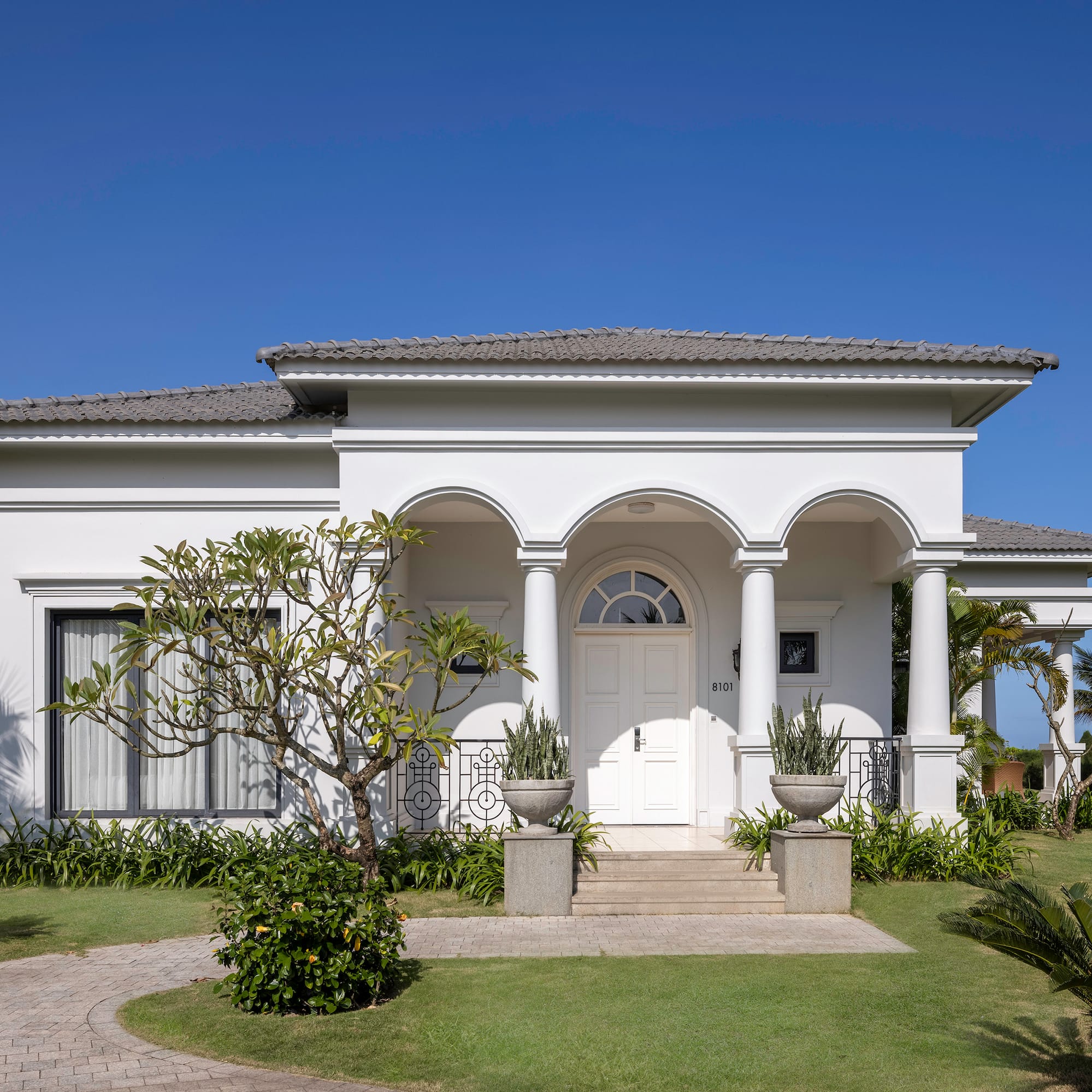 a white house with columns and a lawn