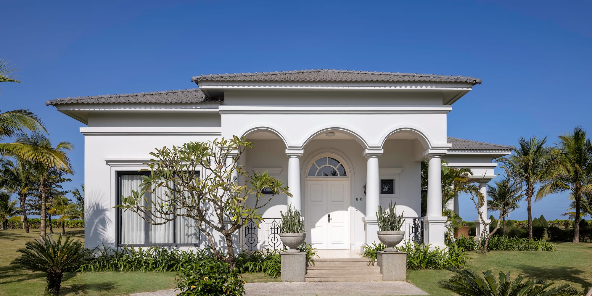 a white house with columns and a lawn