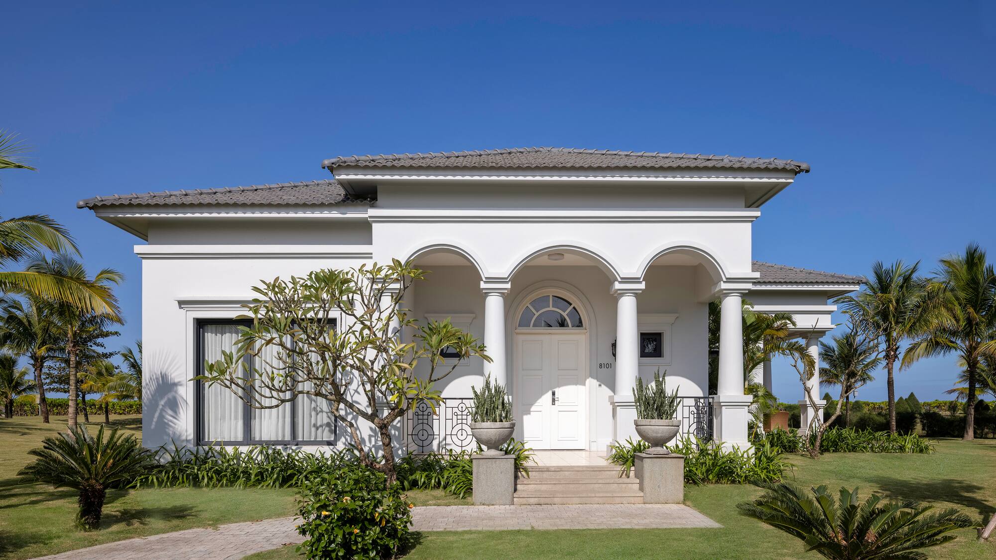 a white house with columns and a lawn