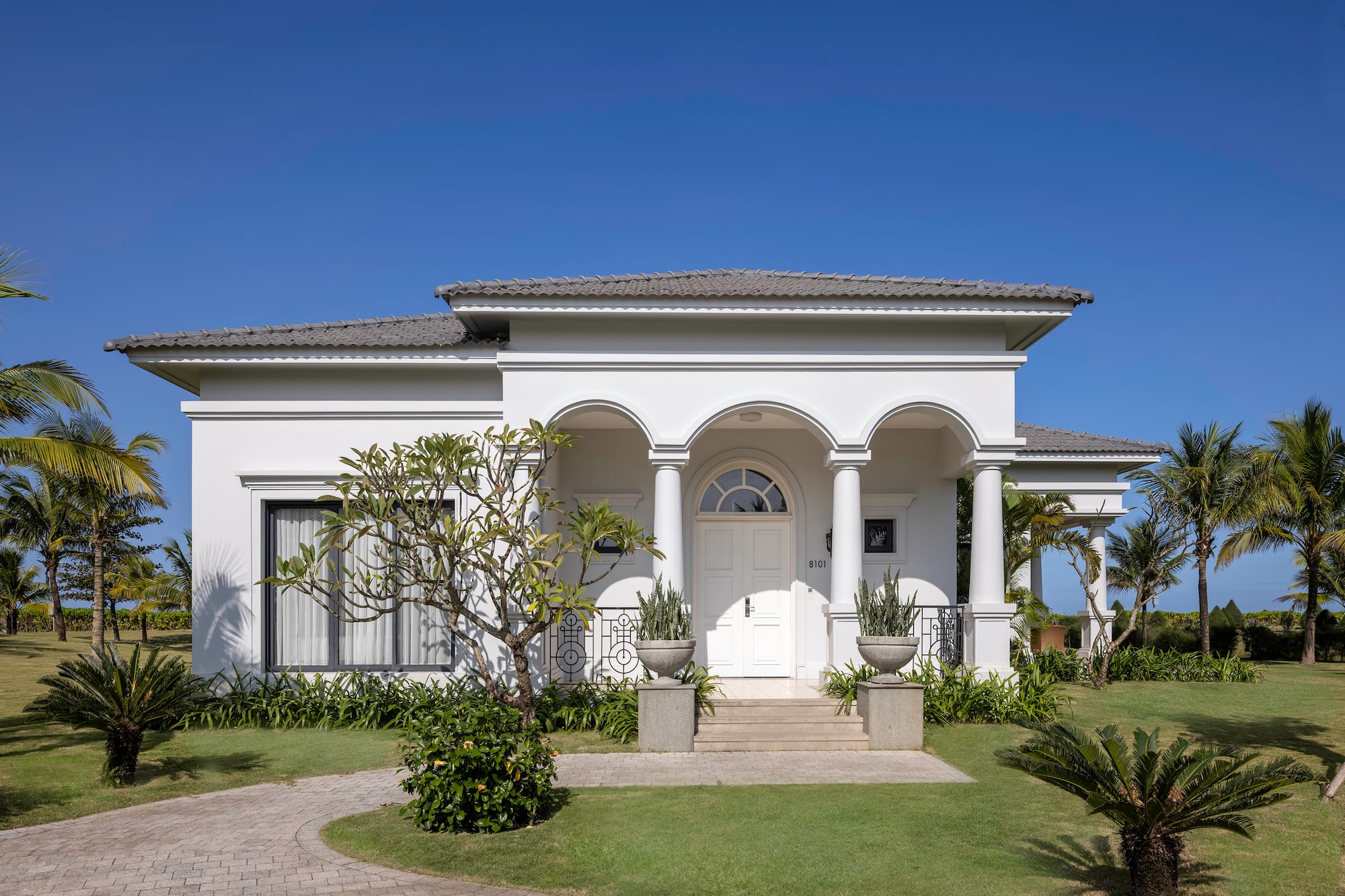a white house with columns and a lawn