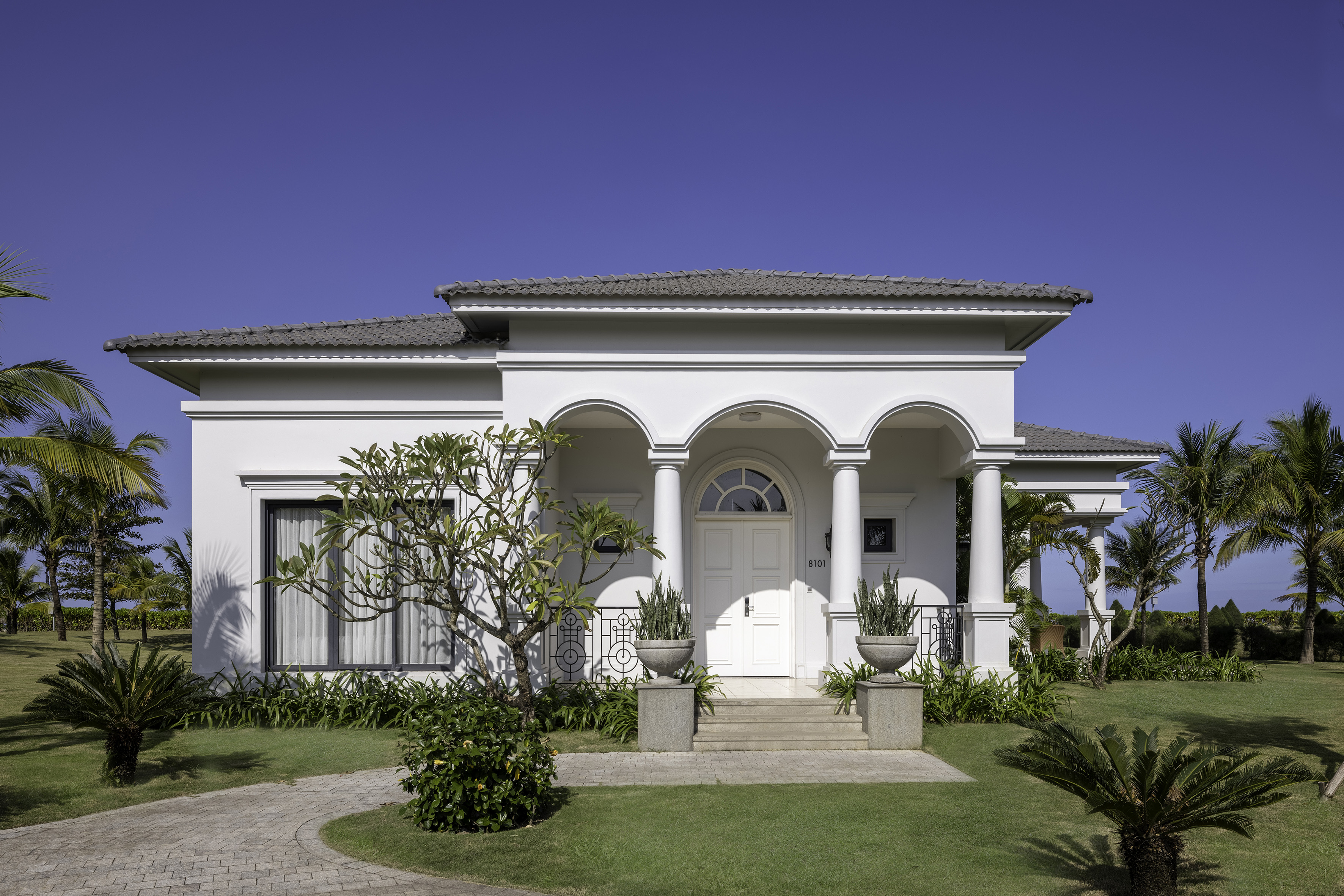 a white house with columns and a lawn