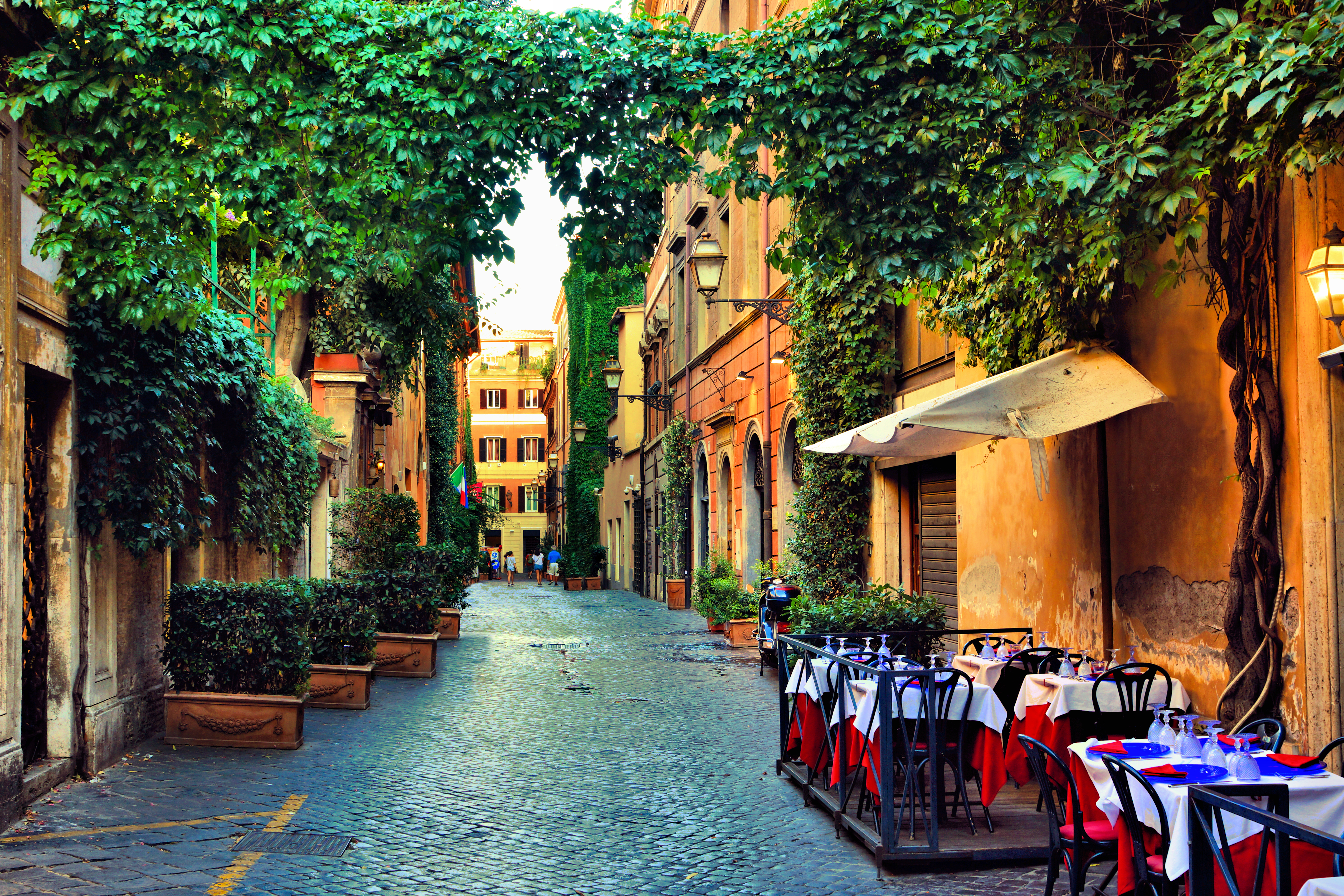 a street with tables and chairs and trees
