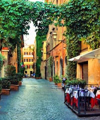 a street with tables and chairs and trees