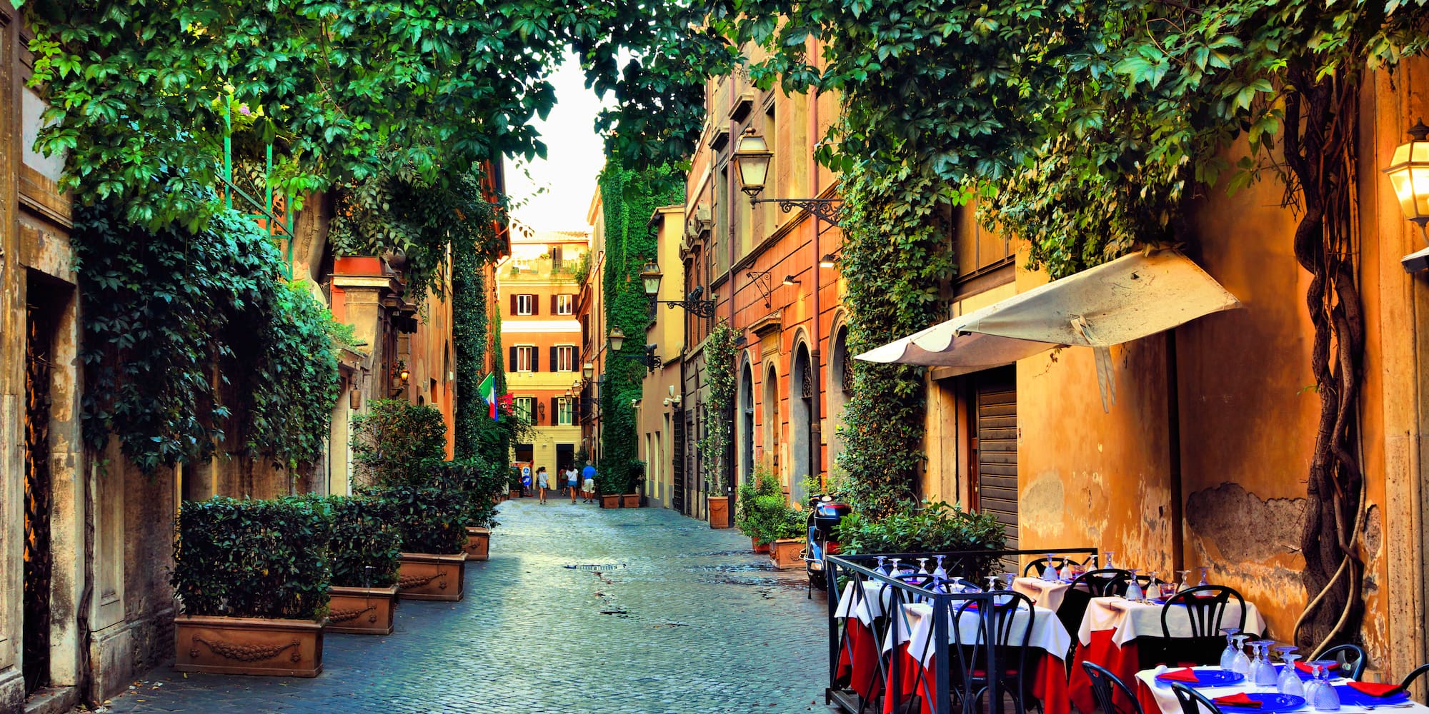a street with tables and chairs and trees