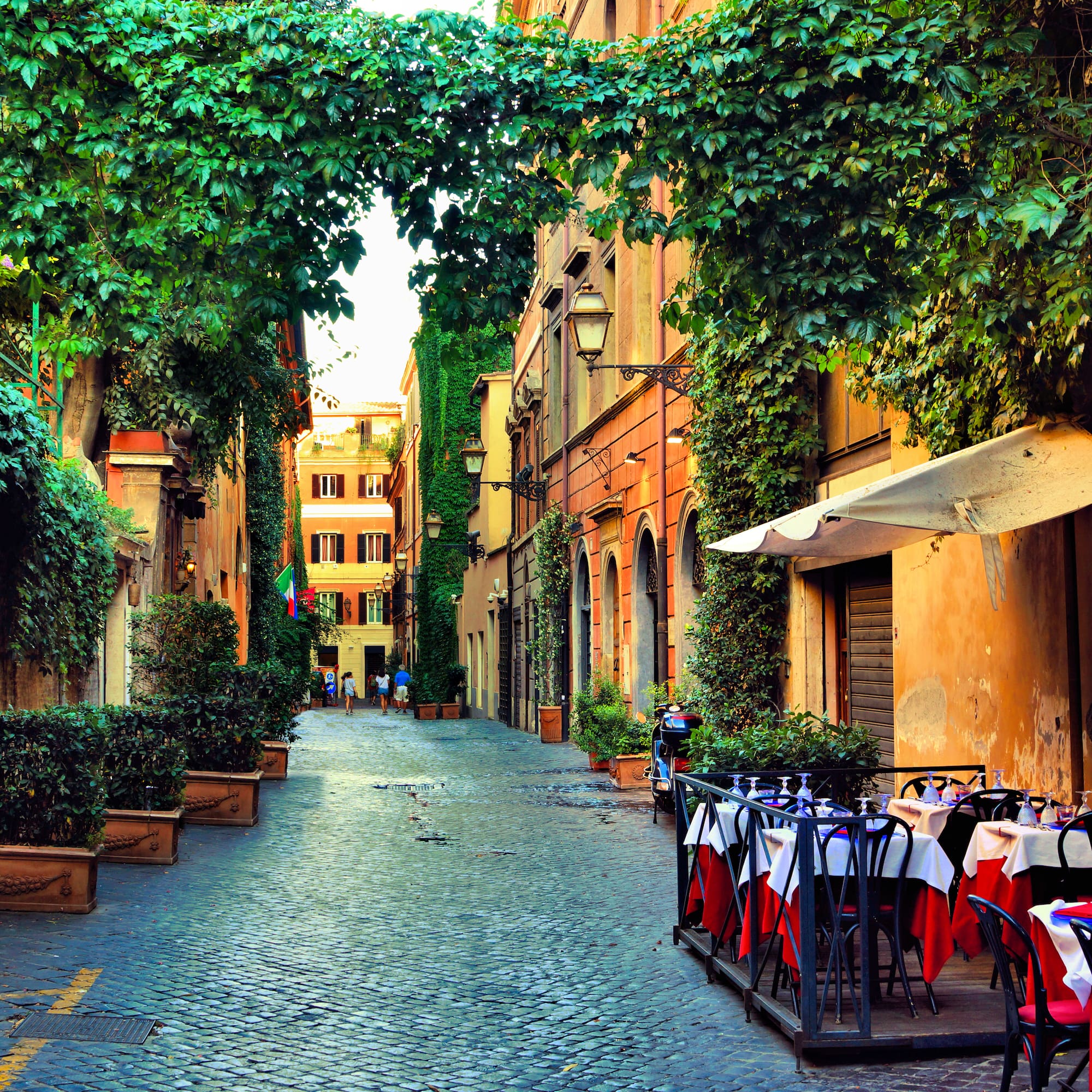 a street with tables and chairs and trees