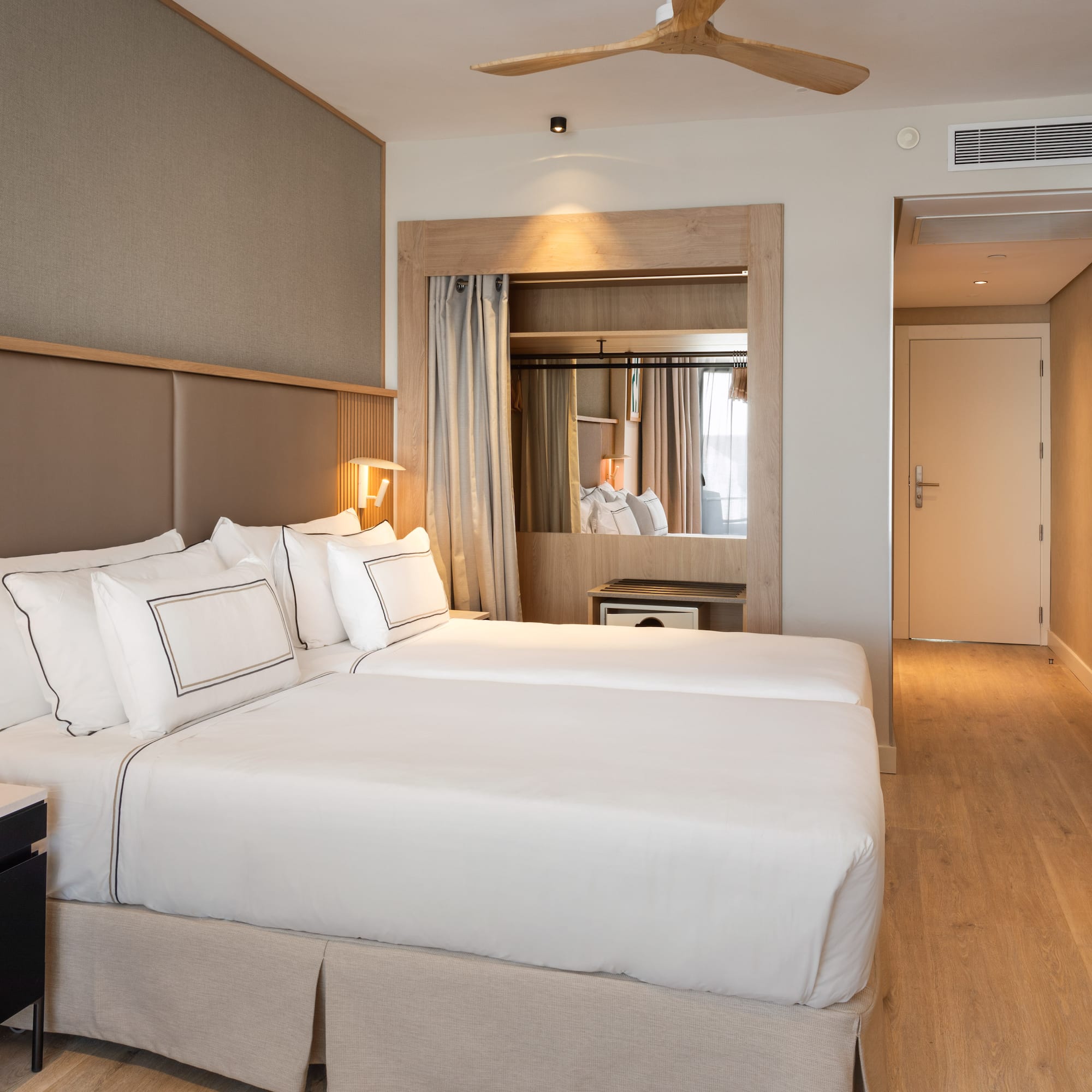 a room with two beds and a ceiling fan