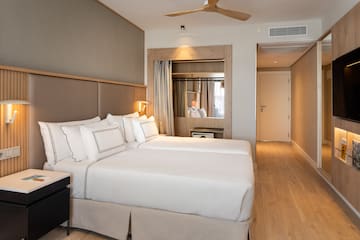 a room with two beds and a ceiling fan