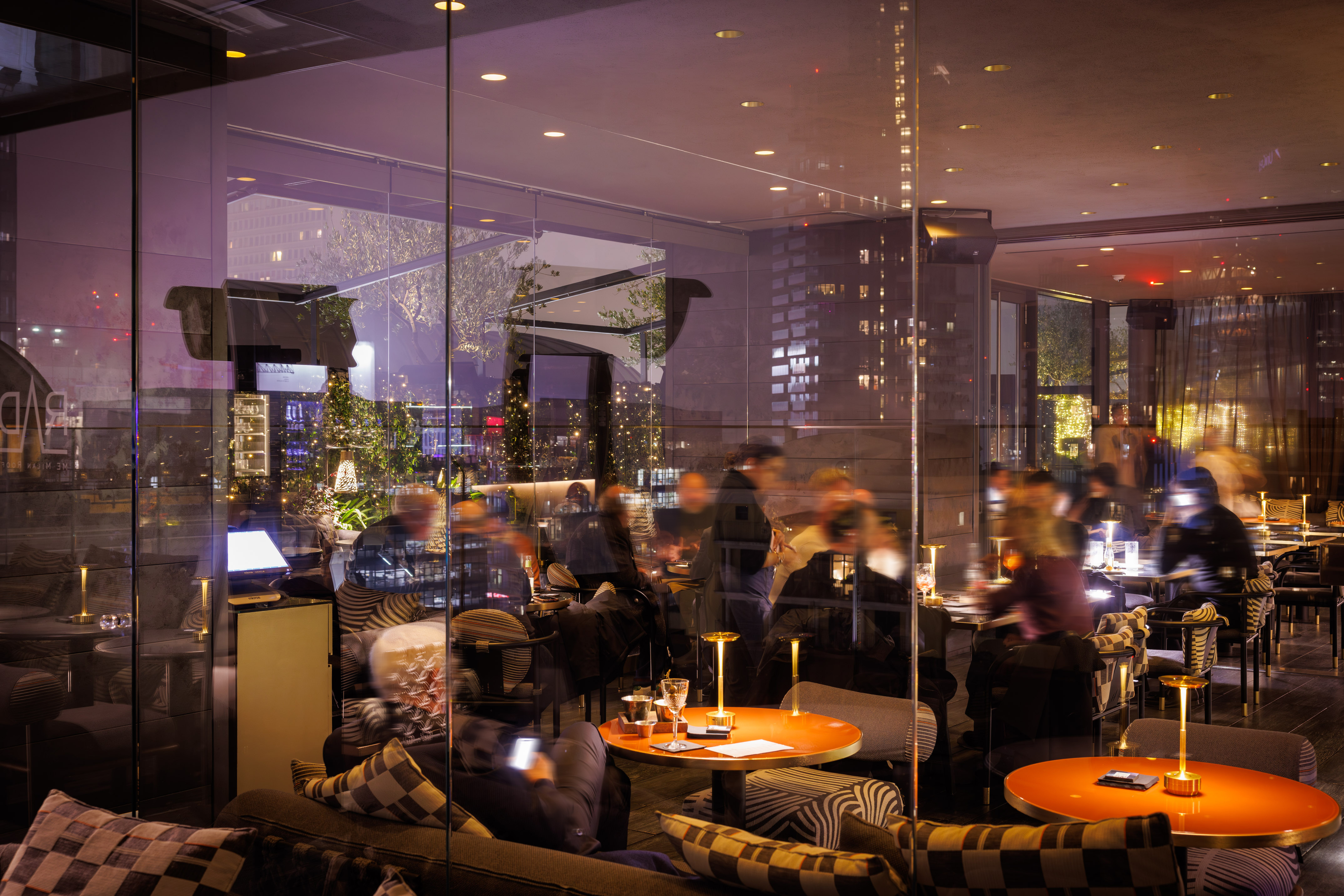 Modern restaurant lounge at night with guests dining and relaxing.