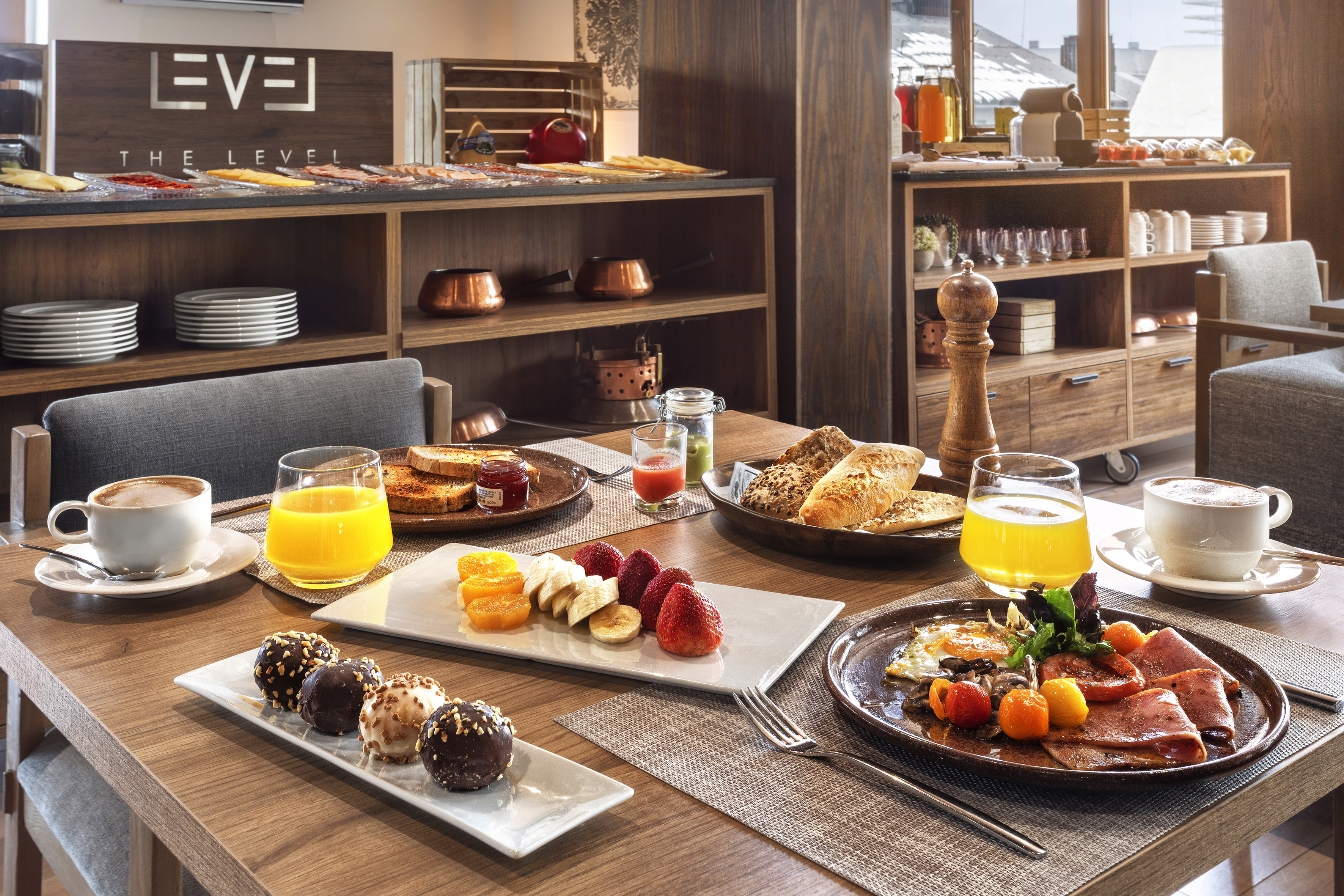The Level hotel breakfast with eggs, ham, fruit, pastries, coffee, and juice.