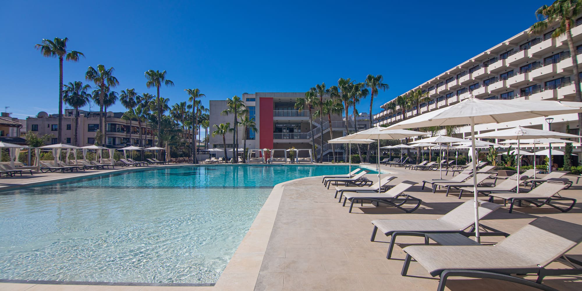 a pool with lounge chairs and umbrellas
