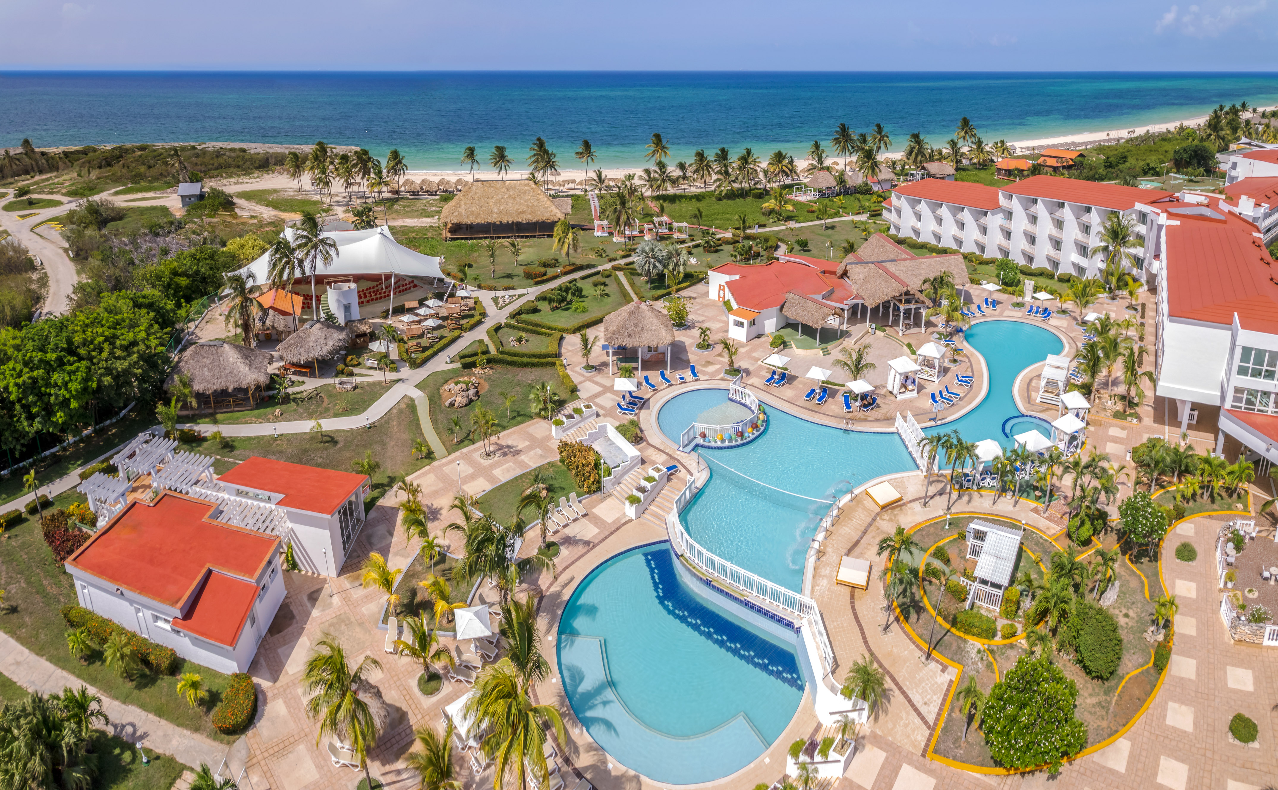 a resort with a swimming pool and a beach with Cayo Coco in the background