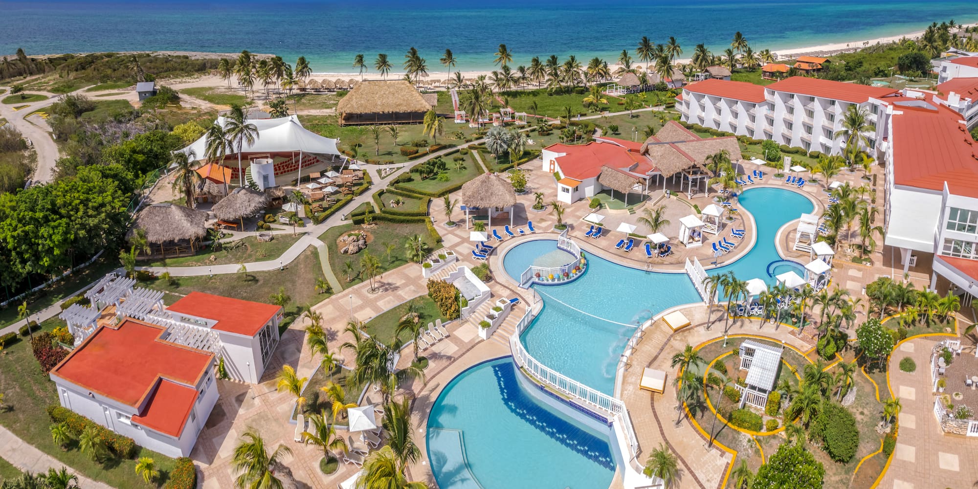 a resort with a swimming pool and a beach with Cayo Coco in the background