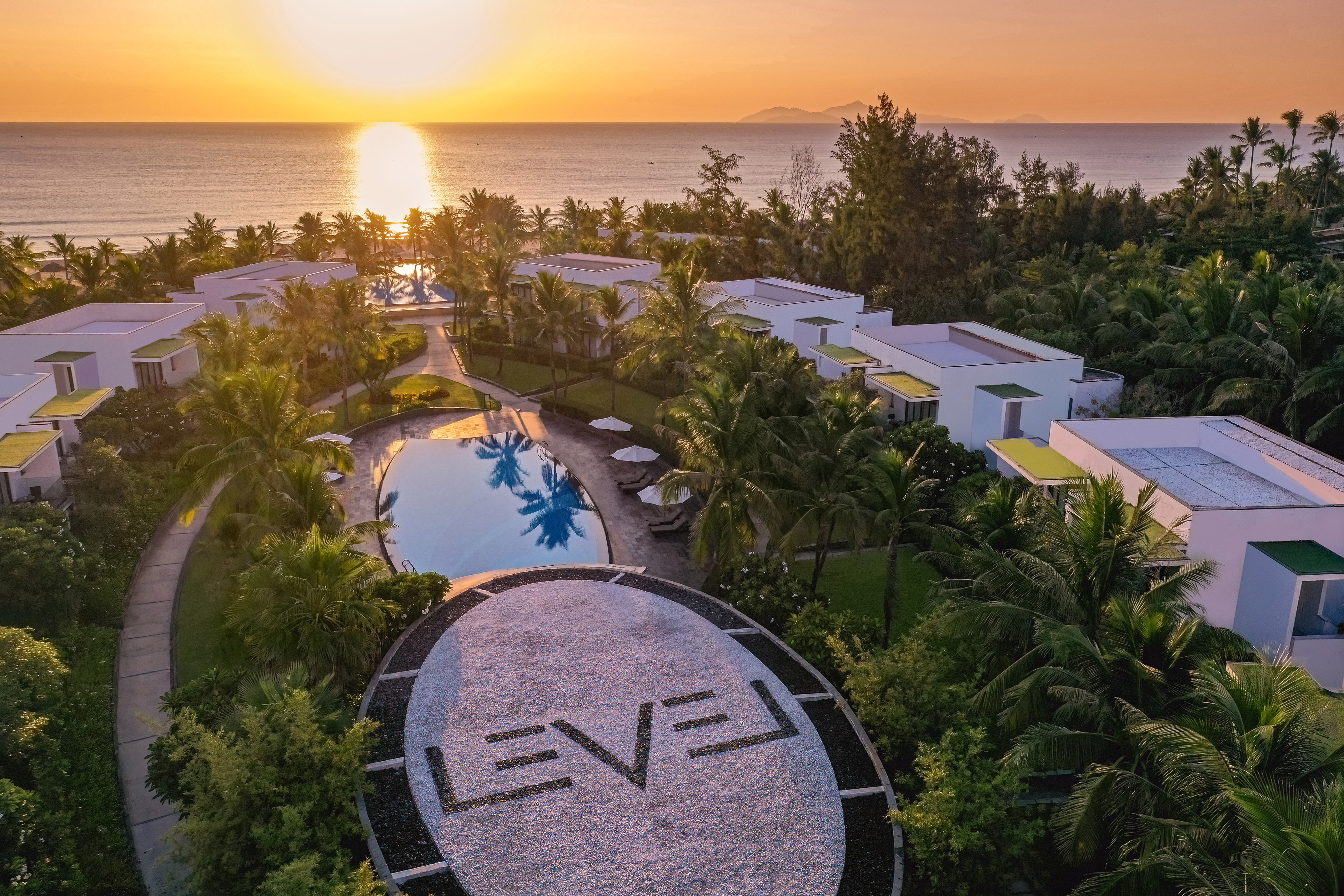 Hãy để bản thân đắm mình trong thế giới xa hoa cùng tiện nghi độc quyền a pool and buildings with trees around it