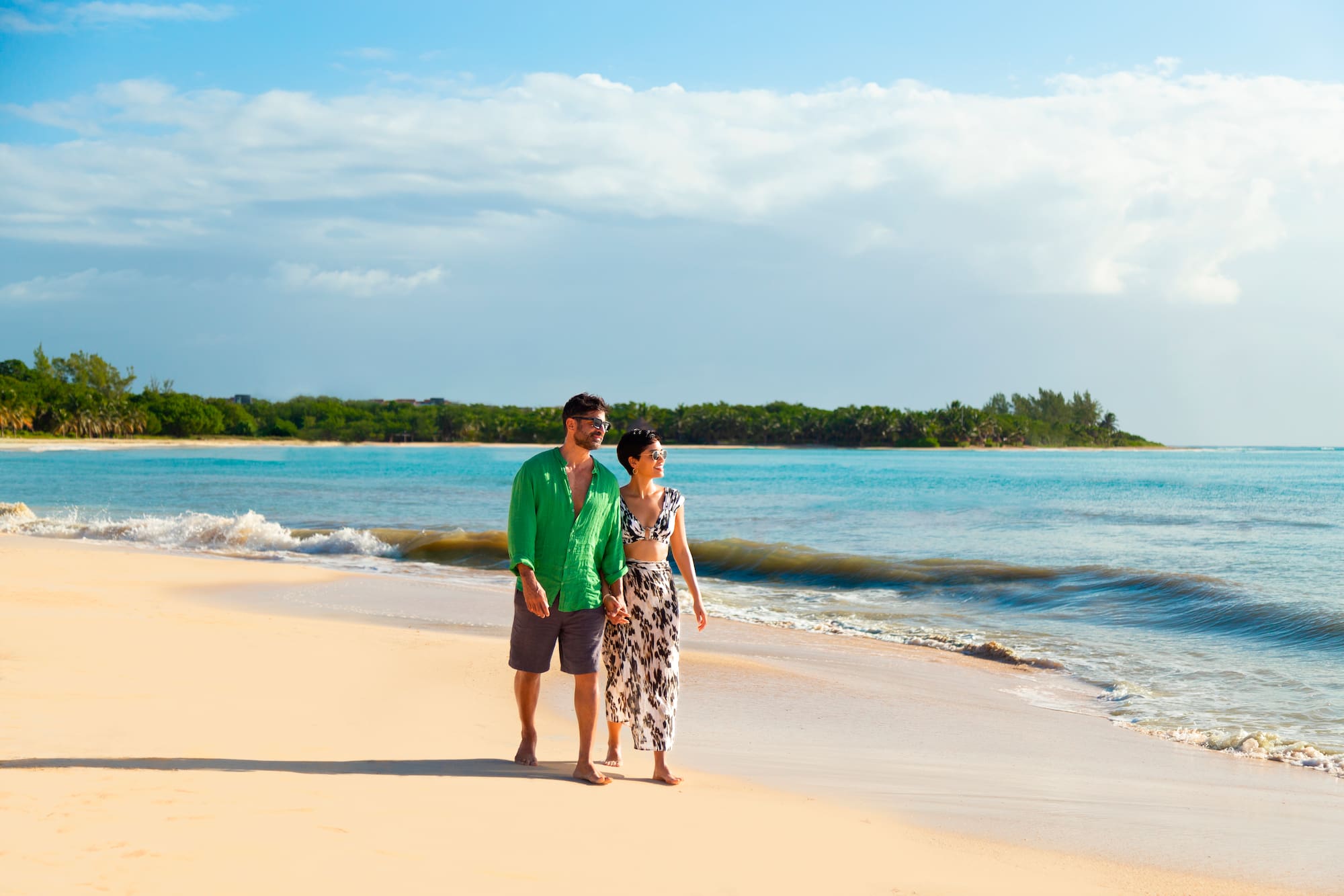 a man and woman walking on a beach