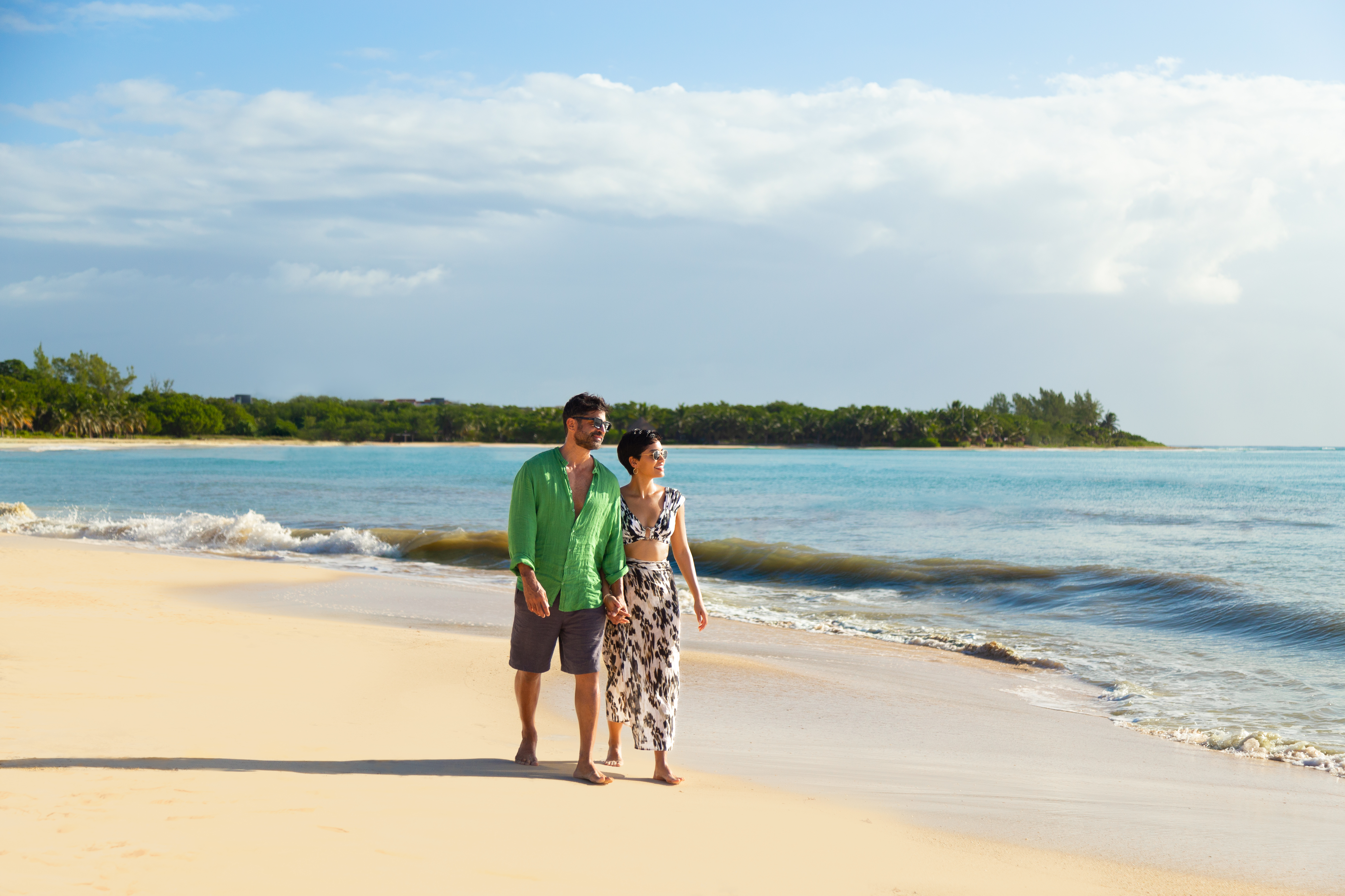 a man and woman walking on a beach