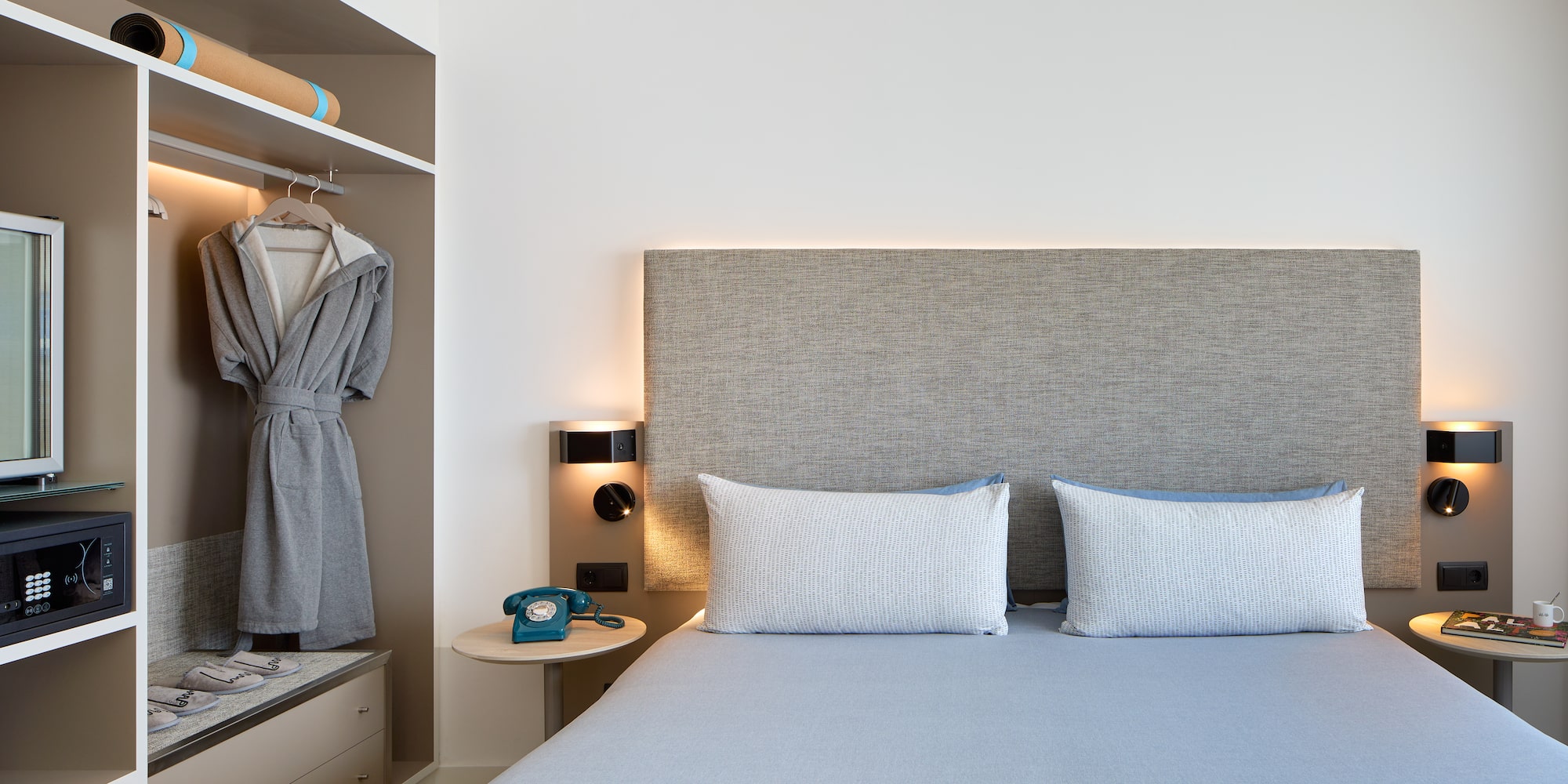 a bed with a headboard and a towel on the shelf