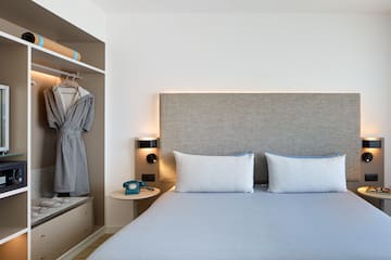 a bed with a headboard and a towel on the shelf