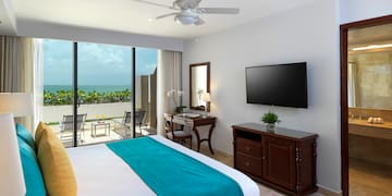 a bedroom with a television and a view of the ocean