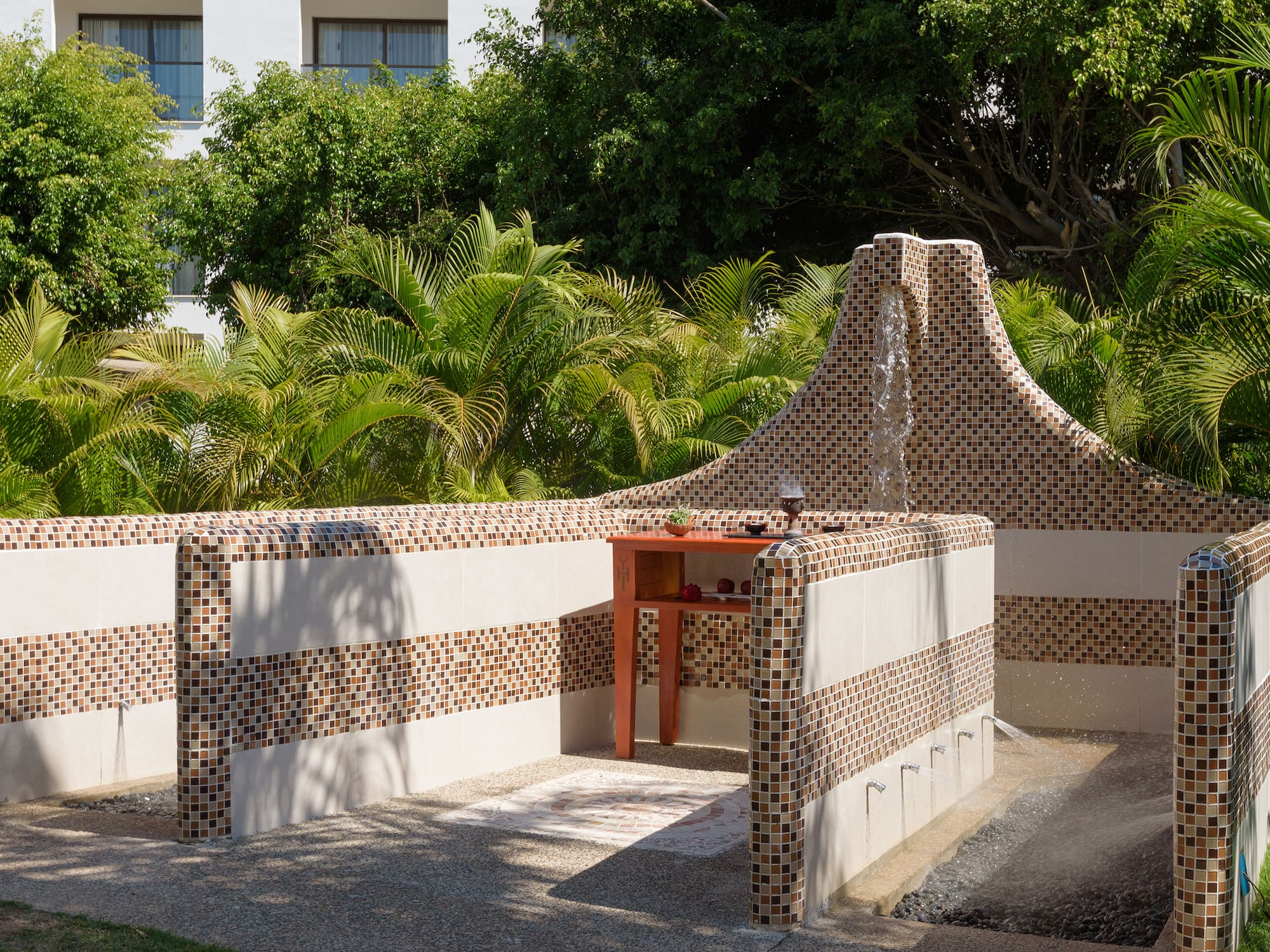 a fountain with a waterfall in the middle of a garden