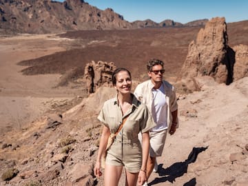 a man and woman walking on a rocky trail