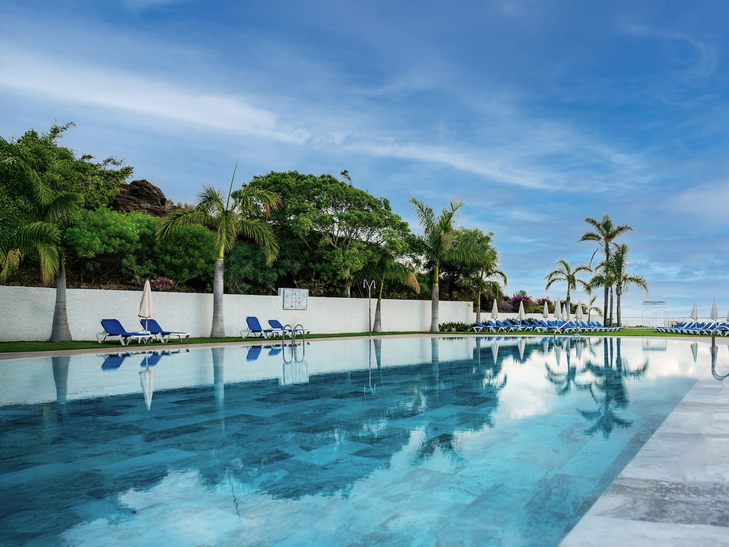a pool with chairs and trees