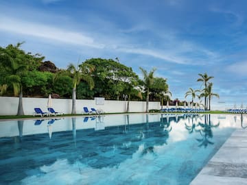 a pool with chairs and trees