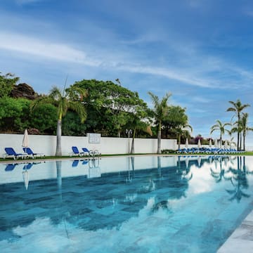 a pool with chairs and trees
