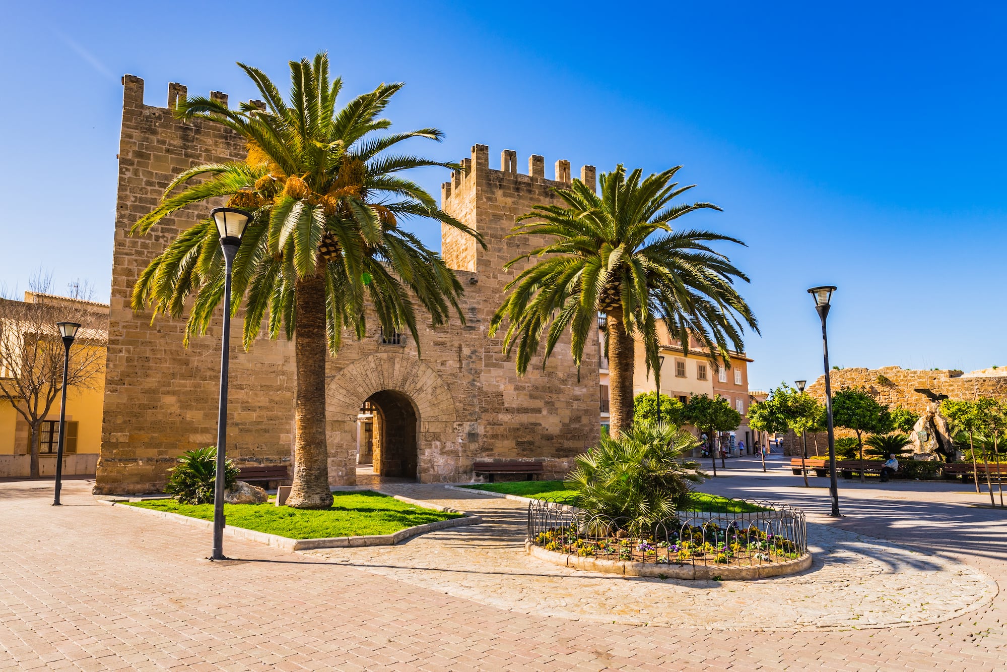 a stone building with palm trees