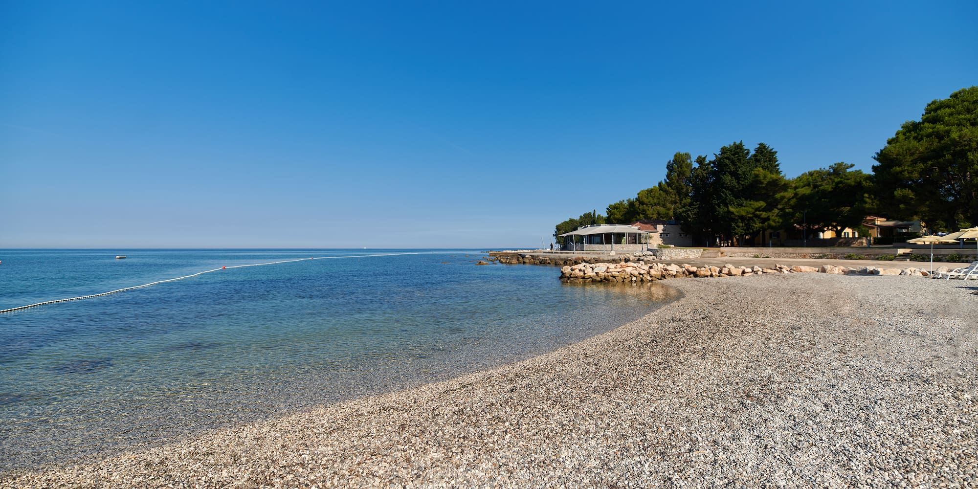 a beach with trees and a building