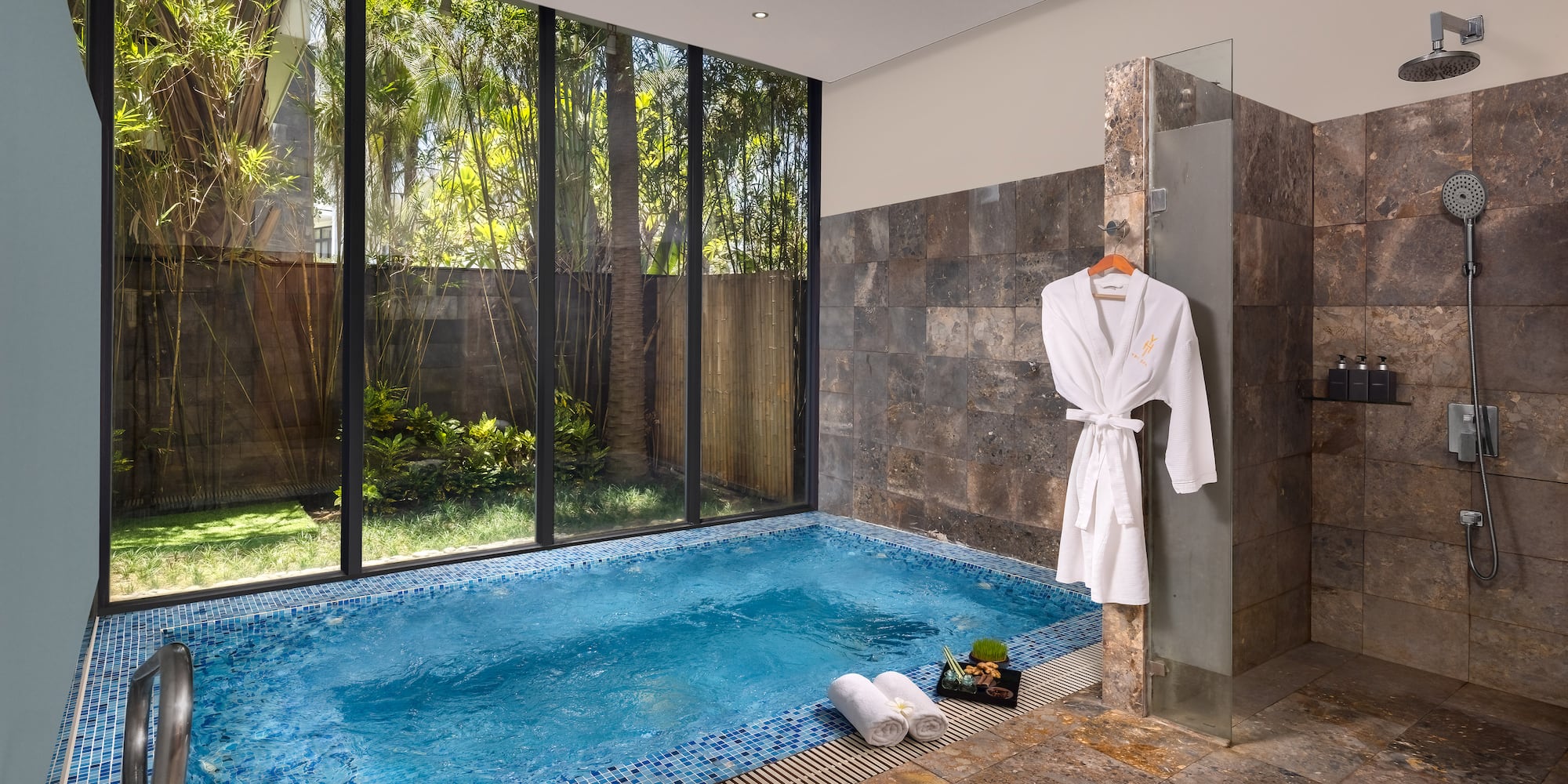 a pool with a bathrobe and towels in a room with windows