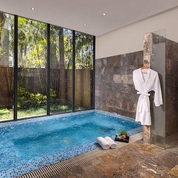 a pool with a bathrobe and towels in a room with windows