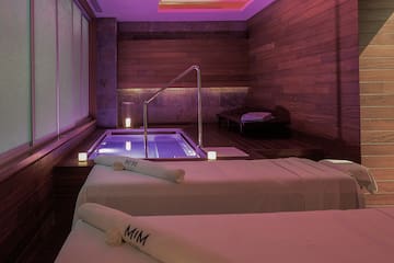 a room with two beds and a hot tub