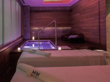 a room with two beds and a hot tub